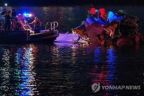 지난 29일(현지시간) 미국 워싱턴 로널드 레이건 공항 인근에서 추락한 비행기 잔해를 수거하고 있는 수색대. [사진출처=연합뉴스]