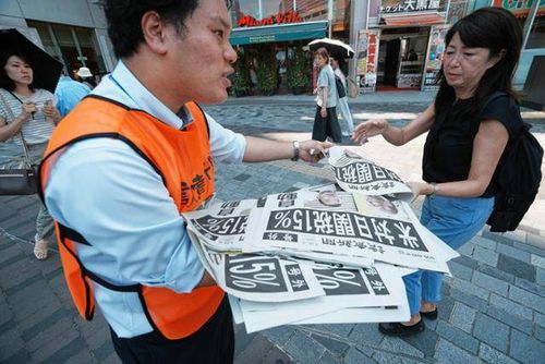 요미우리신문 관계자가 일본 도쿄 시내에서 미국과 일본이 무역 협상을 타결했다는 내용의 호외를 나눠주고 있다. [AP = 연합뉴스]