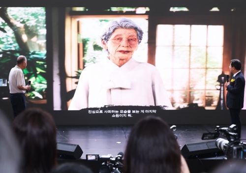 9일 경기도 광주시 나눔의집에서 열린 ‘2025년 일본군 위안부 피해자 기림의 날’ 기념식에서 AI 기술로 복원된 김순덕 할머니가 참석자들과 대화하고 있다. [사진 출처 = 연합뉴스]