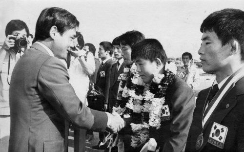 1982년도 세계 주니어 아마 레슬링 선수권대회에 참가한 한국 대표선수단이 귀국하자, 이건희 대한 레슬링협회 회장이 환영식에서 금메달리스트 어경선 선수와 악수하고 있다. 사진 중앙포토