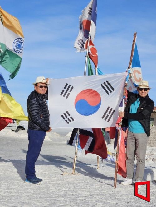 김재욱 BNW인베스트먼트 회장과 엄정욱 JS물산 회장이 볼리비아 포토시 우유니 염호에서 태극기를 들고 기념 사진을 찍고 있다.