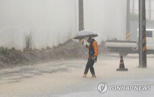 '억수'(광주=연합뉴스) 박철홍 기자 = 광주·전남에 장마전선의 영향으로 많은 비가 내린 29일 오전 광주 북구 중흥동의 주택가에 아파트 공사 현장에서 퍼낸 빗물이 넘쳐흘러 관계자가 배수로를 점검하고 있다. 2020.7.29 pch80@yna.co.kr