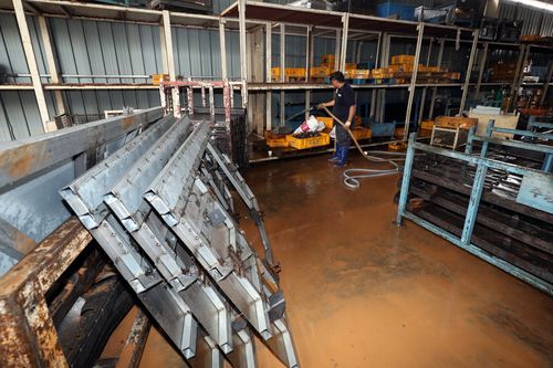 기계 돌아가는 소리 다시 울릴 때까지(광주=연합뉴스) 정회성 기자 = 11일 오후 광주 광산구 소촌농공단지의 자동차 부품 제조업체에서 직원이 최근 수해 때문에 진흙이 엉겨 붙은 자재를 물로 씻어 내고 있다.