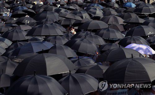 의사 집회에서 펼쳐진 검은우산(부산=연합뉴스) 손형주 기자 = 14일 오후 부산시청 앞에서 열린 4대악 의료정책 저지를 위한 전국의사총파업 부울경 궐기대회에서 참가자들이 어두운 의료계 현실을 보여주기 위해 검은 우산을 펼치는 퍼포먼스를 하고 있다. 2020.8.14 handbrother@yna.co.kr