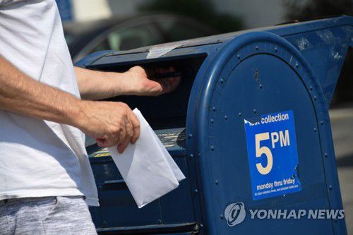 트럼프 대통령은 선거 조작 가능성이 있다며 우편투표 확대에 반대하고 있다. 사진은 미국 남성이 우체통에 우편물을 넣는 모습.[AFP=연합뉴스[