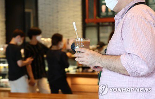 프랜차이즈 카페는 포장만(서울=연합뉴스) 류영석 기자 = 사회적 거리두기 2.5단계가 시행되고 있는 가운데 지난달 31일 오후 서울 성동구의 한 프랜차이즈형 커피전문점을 찾은 시민이 커피를 포장해 나오고 있는 모습. [연합뉴스 자료사진]