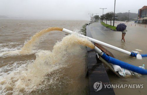 침수 피해를 막아라(강릉=연합뉴스) 양지웅 기자 = 7일 오전 강원 강릉시 진안상가 일대에 폭우로 경포호 물이 넘쳐 침수 피해가 발생해 공무원들이 펌프로 물을 퍼내고 있다. 2020.9.7 yangdoo@yna.co.kr