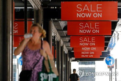 '세일' 표지가 붙은 런던 시내 도로를 지나가는 행인의 모습 [AFP=연합뉴스]