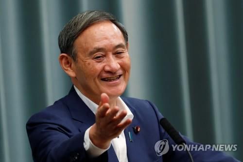 기자회견하는 스가(도쿄 로이터=연합뉴스) 스가 요시히데 관방장관이 14일 정례기자회견에서 밝은 표정을 짓고 있다.