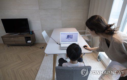 엄마와 집에서, 초등학교 '온라인 입학식'서울의 한 가정에서 초등학교에 입학한 신입생 어린이가 엄마와 함께 노트북 화면을 통해 온라인 입학식을 갖고 있다. [연합뉴스 자료사진]
