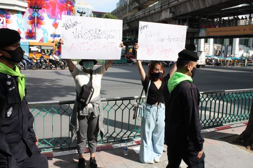 총리신 건물 바깥에서 밤샘 집회를 하다 체포된 반정부 인사들의 석방을 촉구하는 플래카드 시위대 앞으로 경찰들이 지나가고 있다. 2020.10.15
[방콕=연합뉴스 김남권 특파원]