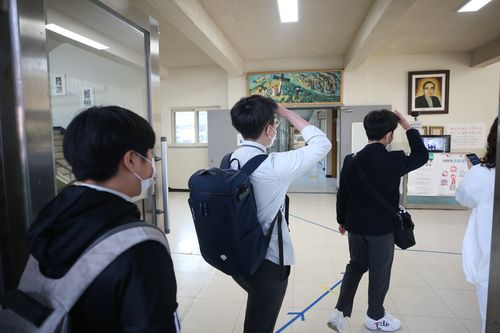 교실 입실 전 발열체크 필수(광주=연합뉴스) 천정인 기자 = 전교생 등교를 시작한 19일 오전 광주 북구 살레시오중학교에서 학생들이 발열 체크를 위해 열화상카메라 앞에서 앞머리를 들어올리고 있다. 2020.10.19 iny@yna.co.kr