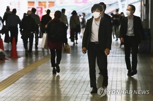 (도쿄 AP=연합뉴스) 일본에서 신종 코로나바이러스 감염증(코로나19)이 급격히 확산하는 가운데 18일 도쿄의 한 지하도에서 사람들이 마스크를 쓰고 이동하고 있다.