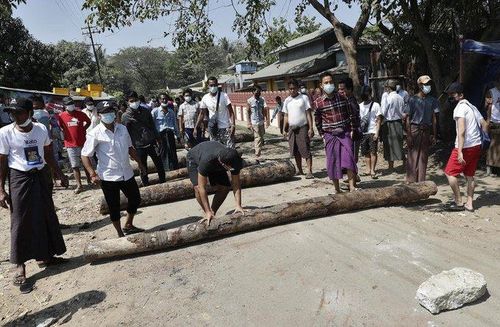 경찰이 시민 불복종 운동에 참여 중인 철도 근로자들의 업무 복귀를 강제하기 위해 진입을 시도하자 나무 둥치나 돌로 입구 도로를 막는 주민들. 2021.2.14
[,EPA=연합뉴스]