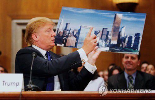 지난해 트럼프 월드 타워 사진을 보여주는 트럼프 전 미국 대통령 [게티이미지/AFP=연합뉴스]