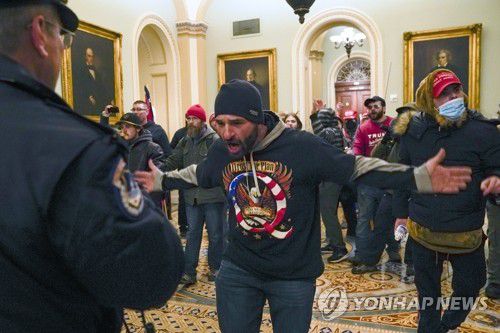 지난달 6일 미 연방의사당에 난입한 도널드 트럼프 대통령 지지자들이 상원 본회의장 밖 복도에서 의회 경찰과 대치하고 있다. [AP=연합뉴스 자료사진]