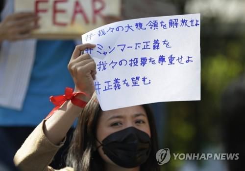 양곤 시내 일본 대사관 밖에서 '우리 지도자를 석방하라, 미얀마에 정의를'이라고 적힌 손팻말을 들고 있는 시위대. 2021.2.10
[EPA=연합뉴스]