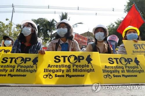 시위대가 야간 불법 체포 행위를 멈추라는 손팻말을 들고 있다. 2021.2.14[AP=연합뉴스]