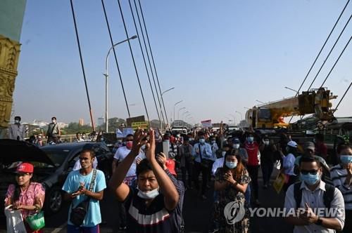 시위대가 차량으로 다리를 막자 일부 시민들이 박수를 치고 있다. 2021.2.17[AFP=연합뉴스]