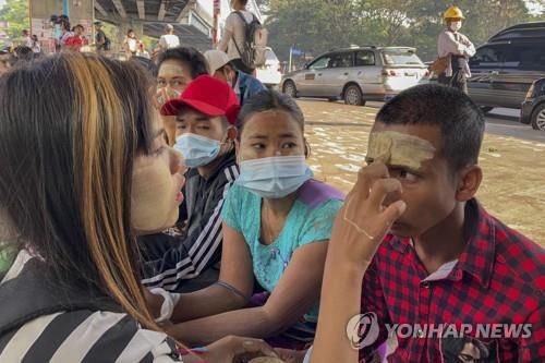 서로 얼굴에 타나카 발라주며 의지 다지는 시민들[AP=연합뉴스]