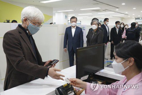 백신접종 과정 지켜보는 문재인 대통령(서울=연합뉴스) 최재구 기자 = 문재인 대통령이 26일 서울 마포구보건소에서 재활시설 종사자인 김윤태 의사(푸르메 넥슨어린이 재활병원)가 코로나바이러스감염증 예방접종을 받기 위해 본인확인을 하는 모습을 지켜보고 있다.   jjaeck9@yna.co.kr