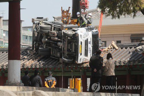 성균관 문묘 동삼문 위로 떨어진 사다리차(서울=연합뉴스) 이정훈 기자 = 8일 오후 서울 종로구 성균관대 문묘 동삼문 지붕 위에 떨어진 사다리차를 들어내기 위한 작업이 이뤄지고 있다.
     문묘내 가지치기 작업을 위해 크레인으로 사다리차를 옮기던중 사고가 발생했다고 한 현장 관계자가 밝혔다. uwg806@yna.co.kr