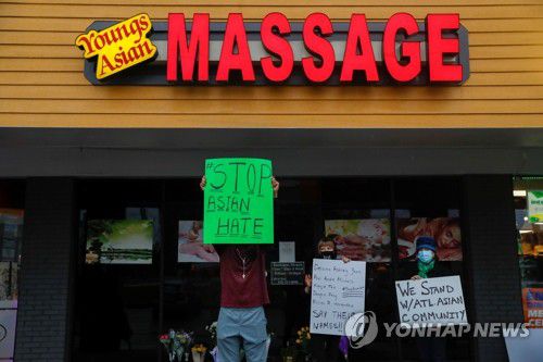 "동양인 혐오 그만" 시위하는 미 애틀랜타 시민들(애크워스 로이터=연합뉴스) 17일(현지시간) 미국 조지아주 애틀랜타 근교 애크워스의 마사지숍 '영스 아시안 마사지 팔러' 입구에서 시민들이 피켓을 들고 동양인 혐오에 대한 반대 시위를 벌이고 있다. 전날 이곳을 포함한 애틀랜타 일대의 마사지숍 1곳과 스파 업소 2곳에서 발생한 연쇄 총격으로 8명의 사망자가 나온 가운데 이 중 4명이 한인 여성인 것으로 알려졌으며 용의자인 로버트 에런 롱(21)은 경찰에 체포됐다. knhknh@yna.co.kr