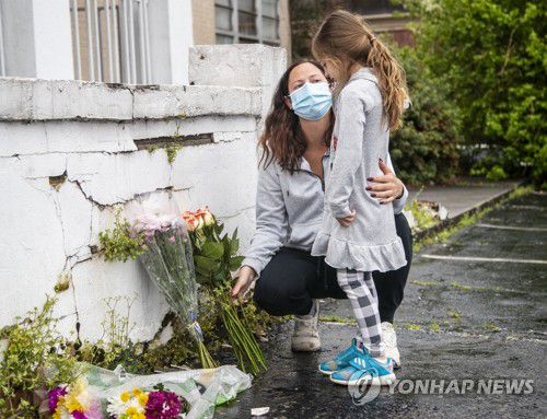 애틀랜타 총격사건 현장에 조화 놓는 미 시민(애틀랜타 AP=연합뉴스) 17일(현지시간) 미국 조지아주 애틀랜타 벅헤드 피드먼트의 마사지업체 '골드스파' 앞에서 한 시민이 딸과 함께 전날 이곳에서 발생한 총격 사건의 희생자들을 애도하며 조화를 놓고 있다. 16일 이곳을 포함한 애틀랜타 일대의 마사지숍 1곳과 스파 업소 2곳에서 발생한 연쇄 총격으로 8명의 사망자가 나온 가운데 이 중 4명이 한인 여성인 것으로 알려졌으며 용의자인 로버트 에런 롱(21)은 경찰에 체포됐다. [애틀랜타 저널-컨스티튜션 제공] knhknh@yna.co.kr