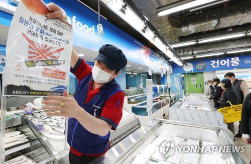 '일본산 수산물 판매하지 않습니다'(서울=연합뉴스) 이진욱 기자 = 일본 정부가  후쿠시마(福島) 제1원전사고로 발생한 다량의 방사성 물질 오염수를 바다에 배출하기로 결정한 13일 오후 서울 도봉구 창동 하나로마트 창동점 수산물코너에서 관계자가 '일본산 수산물을 판매하지 않는다'는 안내문을 붙이고 있다. 2021.4.13 cityboy@yna.co.kr