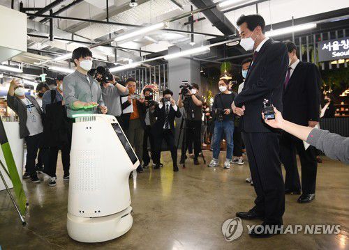 서울창업허브 방문한 오세훈 서울시장(서울=연합뉴스) 박동주 기자 = 오세훈 서울시장이 21일 오후 서울 마포구 서울창업허브를 찾아 스타트업 업체가 개발한 인공지능 방역, 안내 로봇을 살펴보고 있다. 2021.4.21 pdj6635@yna.co.kr