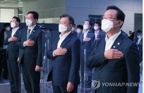 국기에 경례하는 문 대통령(울산=연합뉴스) 이진욱 기자 = 문재인 대통령이 6일 오후 울산광역시 남구 3D프린팅 지식산업센터에서 열린 '울산 부유식 해상풍력 전략 보고'에 참석, 국기에 경례하고 있다. 오른쪽부터 송철호 울산시장, 문 대통령, 더불어민주당 송영길 신임대표. 2021.5.6 cityboy@yna.co.kr