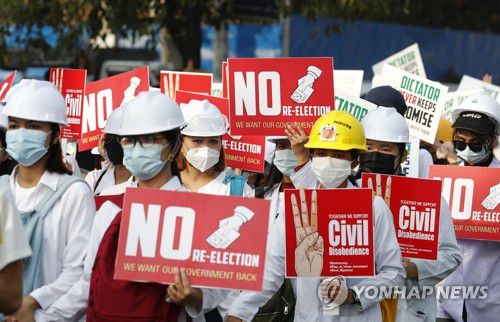 군부 쿠데타 항의하는 미얀마 의료인들(양곤 EPA=연합뉴스) 미얀마 최대 도시 양곤에서 28일(현지시간) 의료계 종사자들이 쿠데타에 대한 항의 표시로 '세 손가락 경례' 그림이 그려진 팻말 등을 들고 시위를 벌이고 있다. 미얀마에서는 지난 1일 군부 쿠데타가 발발한 이후 전국 주요 도시에서 연일 대규모 항의 시위가 이어지고 있다. 2021.2.28 sungok@yna.co.kr