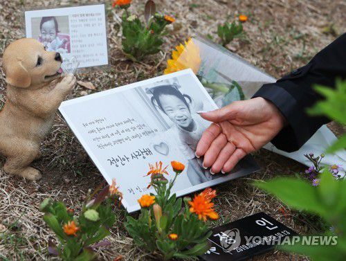 정인이를 추모하며(양평=연합뉴스) 홍기원 기자 = 어린이날을 하루 앞둔 4일 오후 경기도 양평군 하이패밀리 안데르센 공원묘원에서 한 시민이 양부모의 학대로 생후 16개월 만에 사망한 정인 양 사진을 어루만지고 있다. 2021.5.4 xanadu@yna.co.kr