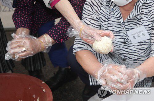 "41년 전 그날처럼"…5·18 주먹밥 재현(광주=연합뉴스) 천정인 기자 = 16일 오후 광주 서구 양동행정복지센터 앞에서 제41주년 5·18 민주화운동을 기념해 당시 양동시장에서 주먹밥을 싸 시민들에게 나눠준 노점상들이 상황을 재현하고 있다. 2021.5.16 iny@yna.co.kr