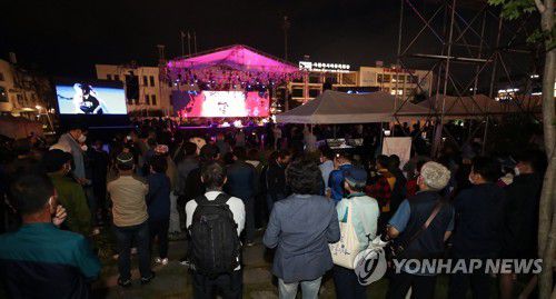 초청장은 없어도 5·18 전야제 관람(광주=연합뉴스) 정회성 기자 = 17일 오후 광주 동구 옛 전남도청 앞 광장에서 5·18 민주화운동 41주년 전야제가 열려 코로나19 예방을 위한 방역지침으로 인해 초청장을 받지 못한 시민이 행사장 주변에 모여 공연을 감상하고 있다. 2021.5.17 hs@yna.co.kr