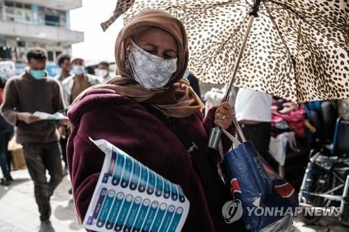 17일 아디스아바바에서 한 에티오피아 여성이 투표용 정당명부를 바라보고 있다.[AFP=연합뉴스]