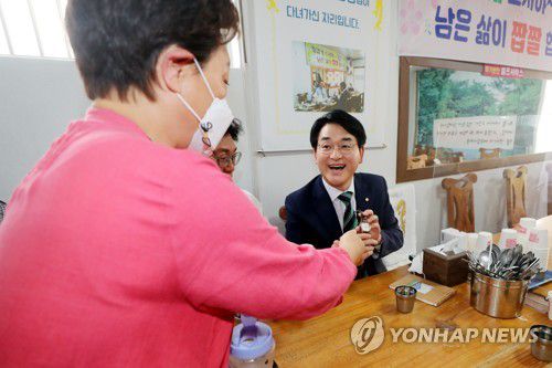 시계 선물받는 박용진(전주=연합뉴스) 정경재 기자 = 대선 출마를 선언한 더불어민주당 박용진 의원이 24일 전북 전주시 왱이콩나물국밥집에서 열린 청년정치인 간담회 도중 음식점 사장인 유대성 씨에게 선물받은 '청와대'라고 쓰인 시계를 착용하기 위해 자신의 시계를 풀고 있다.  2021.6.24 jaya@yna.co.kr