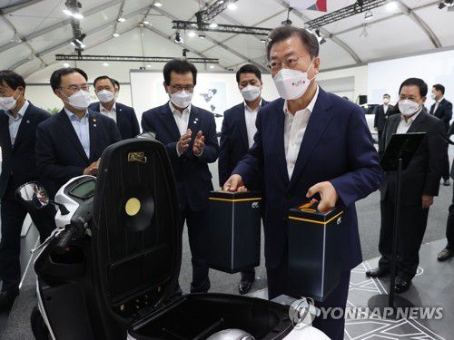 교체형 배터리 들어보는 문재인 대통령(청주=연합뉴스) 최재구 기자 = 문재인 대통령이 8일 충북 청주시 LG에너지솔루션 오창 제2공장에서 열린 K-배터리 발전전략 보고 'K-배터리, 세계를 차지(charge)하다'에서 행사에 앞서 관련 전시물을 관람하며 오토바이용 교체 배터리를 직접 들어보고 있다. 2021.7.8 jjaeck9@yna.co.kr