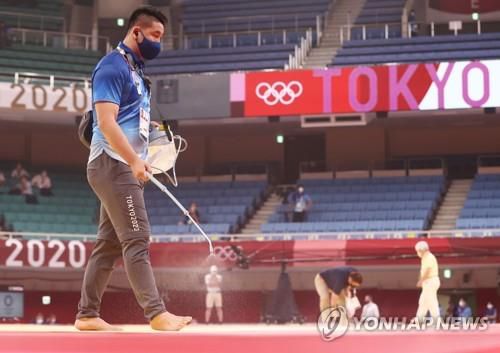 (도쿄=연합뉴스) 신준희 기자 = 25일 도쿄 일본무도관에서 열린 도쿄올림픽 유도 여자 52kg급 경기에 앞서 코로나19 예방을 위한 매트 소독작업이 이뤄지고 있다. hama@yna.co.kr