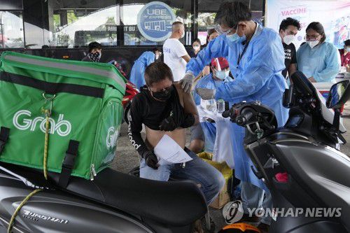 중국산 코로나19 백신 맞는 필리핀 시민[마닐라 AP=연합뉴스 자료사진] 2021년 6월 22일(현지시간) 필리핀 마닐라의 신종 코로나바이러스 감염증(코로나19) 드라이브 스루 접종소에서 한 오토바이 배달 기사가 중국산 시노백 백신을 접종받고 있는 모습. leekm@yna.co.kr