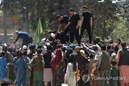 탈레반과 정부군간 교전지역에서 탈출한 아프간인들이 수도 카불 한 공원에서 무료 배식을 위해 모여 있다.[AFP=연합뉴스]