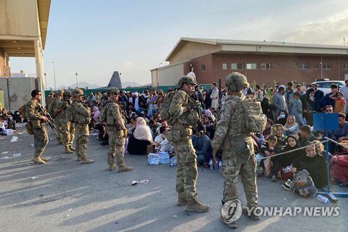 미군 수송기 탑승 기다리는 아프간인들(카불 AFP=연합뉴스) 19일(현지시간) 아프가니스탄 카불 국제공항에서 미군 병사들이 출국을 위해 미군 수송기 탑승을 기다리는 아프간인들을 통제하고 있다. jsmoon@yna.co.kr