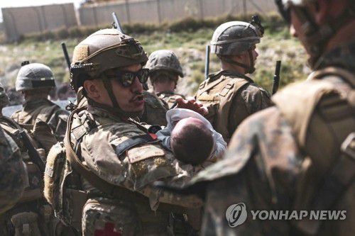 아프간 아기 품에 안은 미 해병대원(카불 AFP=연합뉴스) 20일(현지시간) 아프가니스탄 수도 카불의 하미드 카르자이 국제공항을 경비하는 미국 해병대원이 아기를 품에 안고 달래고 있다. [미군 중부사령부 제공. 재판매 및 DB 금지] jsmoon@yna.co.kr