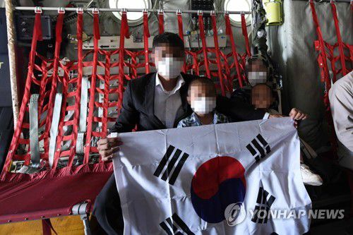 태극기 펼쳐 보이는 아프간 현지 조력자와 가족들(서울=연합뉴스) 한국으로 이송될 아프간 현지 조력자와 가족들이 25일 아프가니스탄 카불공항에서 공군 C-130J 수송기에 탑승해 태극기를 펼쳐 보이고 있다. 2021.8.26      [공군 제공. 재판매 및 DB 금지] photo@yna.co.kr