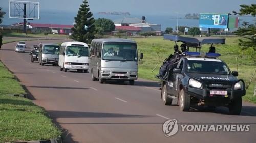 25일 우간다에 도착한 아프간 대피자들을 호송하는 우간다 경찰 [우간다 방송사 화면 캡처, AFP=연합뉴스 재판매 및 DB 금지]