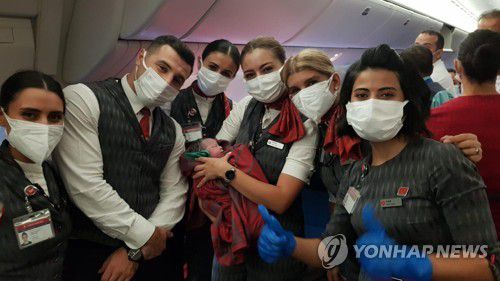 터키항공 승무원들이 기내에서 태어난 아이를 안고 웃고 있다. [터키항공 제공/AP=연합뉴스. 재판매 및 DB 금지]