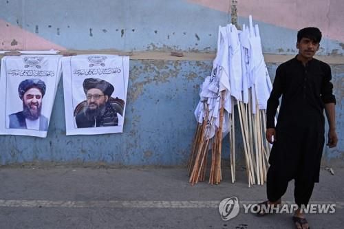 탈레반의 '2인자' 압둘 가니 바라다르의 사진이 담긴 깃발을 파는 아프간 수도 카불의 상인. [AFP=연합뉴스]
