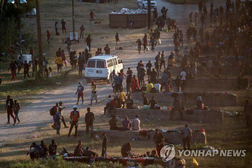 미국 텍사스주 델리오와 멕시코 시우다드아쿠냐를 연결하는 '델리오 국경 다리' 인근에 15일(현지시간) 이민자들이 모여있다. [로이터=연합뉴스]