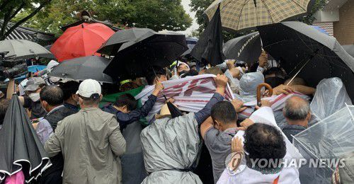 윤석열 방문 막아선 보수단체 회원들(구미=연합뉴스) 김현태 기자 = 국민의힘 대권주자인 윤석열 전 검찰총장이 17일 경북 구미시 상모동에 있는 박정희 전 대통령의 생가를 찾은 가운데 보수단체 회원들이 윤 전 총장의 진입을 막아서고 있다. 2021.9.17 mtkht@yna.co.kr
