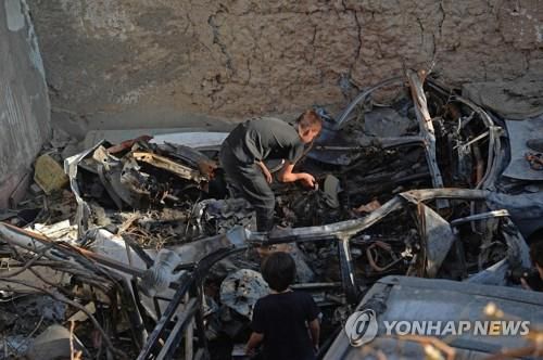 아프간 카불 미국 드론 오폭 사고 현장에서 차량을 살펴보는 희생자의 가족. [AFP=연합뉴스]